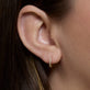 Image of 10K Yellow Gold Bezel Diamond Huggies on Models Ear