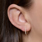 Image of 14K Yellow Gold Classic Diamond Pave Huggies on Models Ear