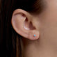 Image of 14K Yellow Gold Tiny Birthstone Earring with Blue Topaz on Models Ear