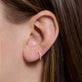 Image of 10K Yellow Gold Dainty White Diamond Pave Huggie Earrings on Models Ear